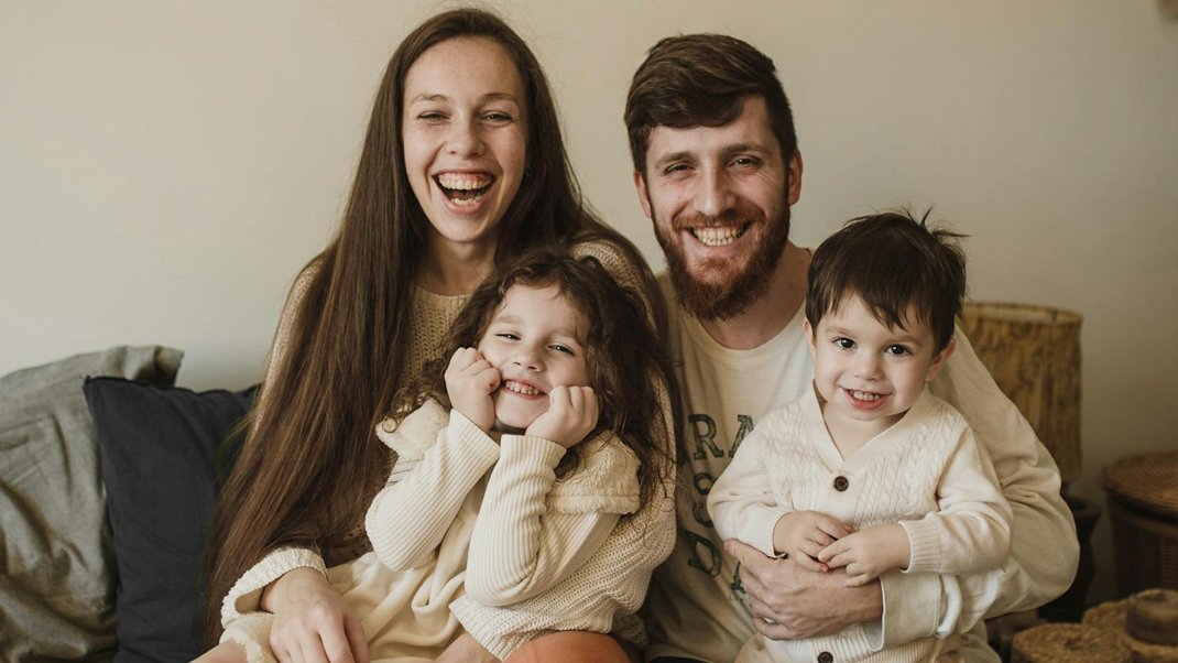 A family sitting on the couch together