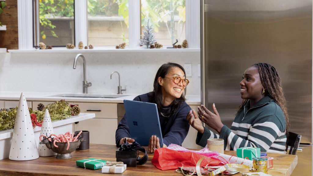 Two friends sitting in the kitchen talking and wrapping presents
